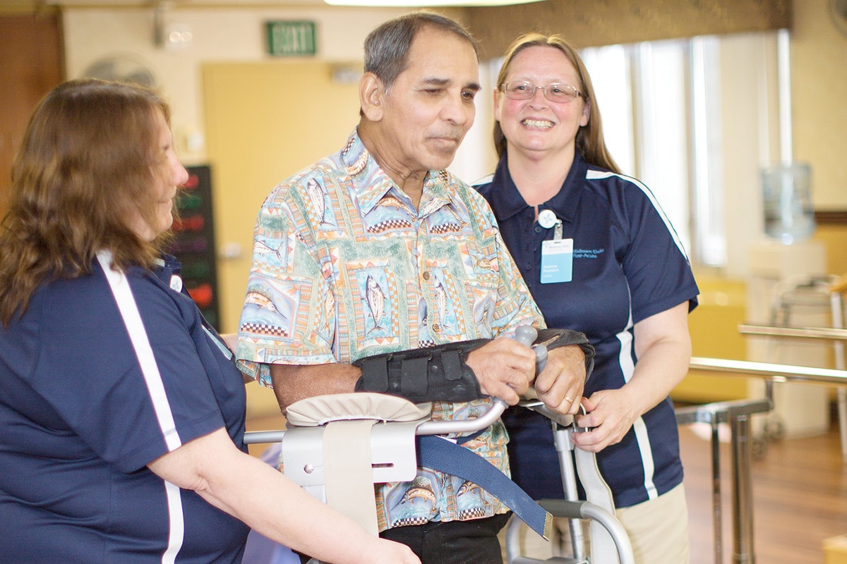 Two nurses with a resident at the Midtown Oaks rehab gym